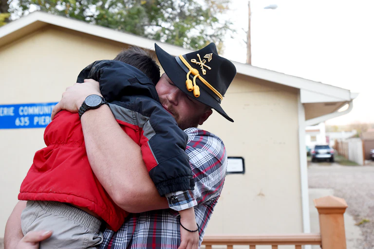 A veteran hugging his young son.