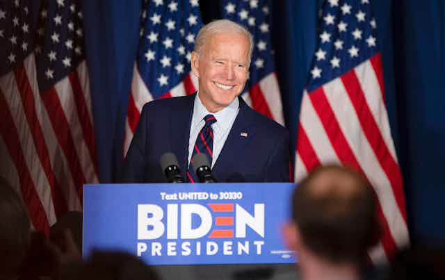 Joe Biden smiling while stood at election campaign lectern
