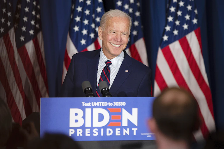 Joe Biden smiling while stood at election campaign lectern