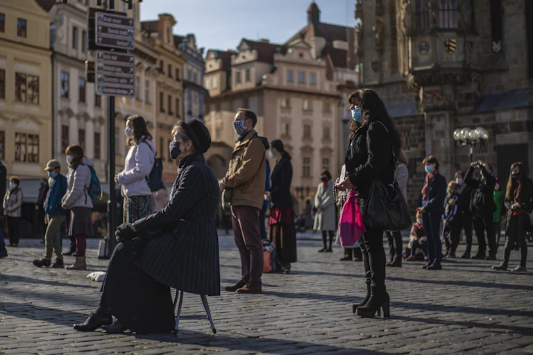 People stand at a distance in the street for an outdoor mass.