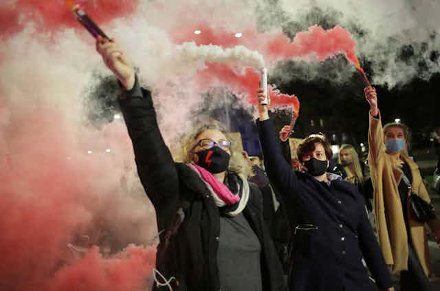 Women protest with flares in Poland. 