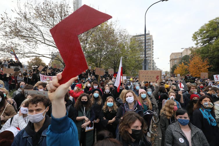 People in masks march in Poland.