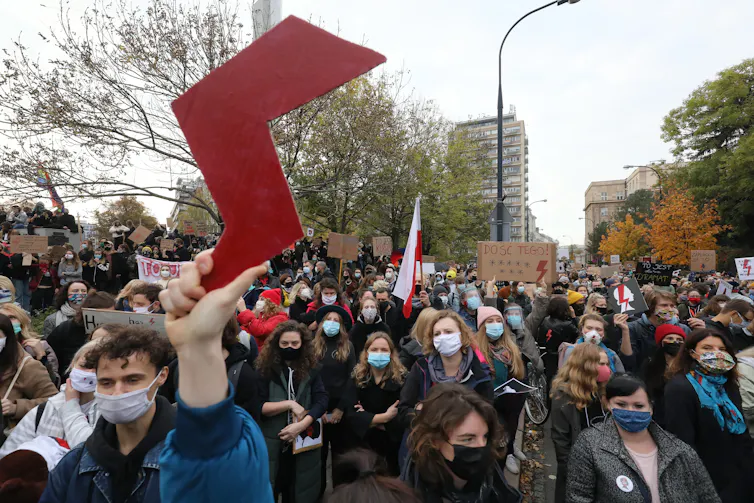 People in masks march in Poland.