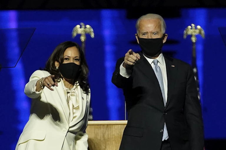 Kamala Harris and Joe Biden point to their crowd of supporters after giving their victory speeches.
