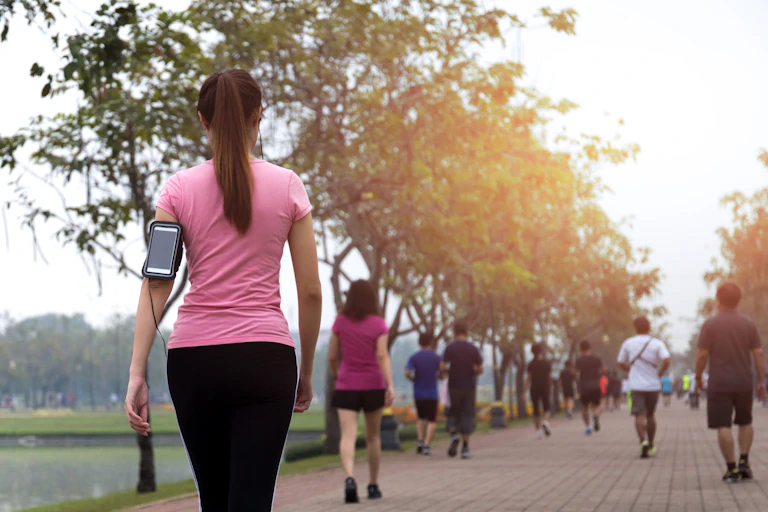 A woman wearing a smartphone goes walking.