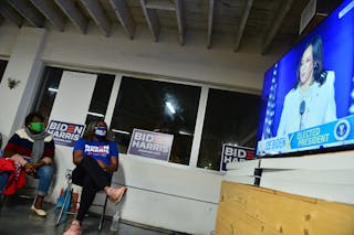 Zwei schwarze Frauen, die Biden / Harris-Hemden tragen, sehen zu, wie Harris in Weiß im Fernsehen spricht. 7, 2020 in Miami, Florida. Johnny Louis / Getty Images