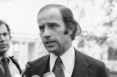 A young Biden is seen talking to the media.