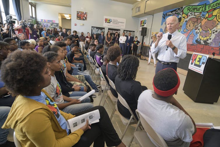 Biden talks in front of a classroom of young people.