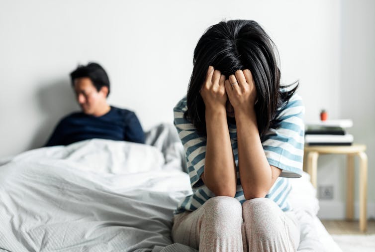 Couple fighting in bed.