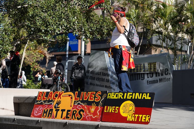 A person speaks on stage at a Black Lives Matter protest in Australia.