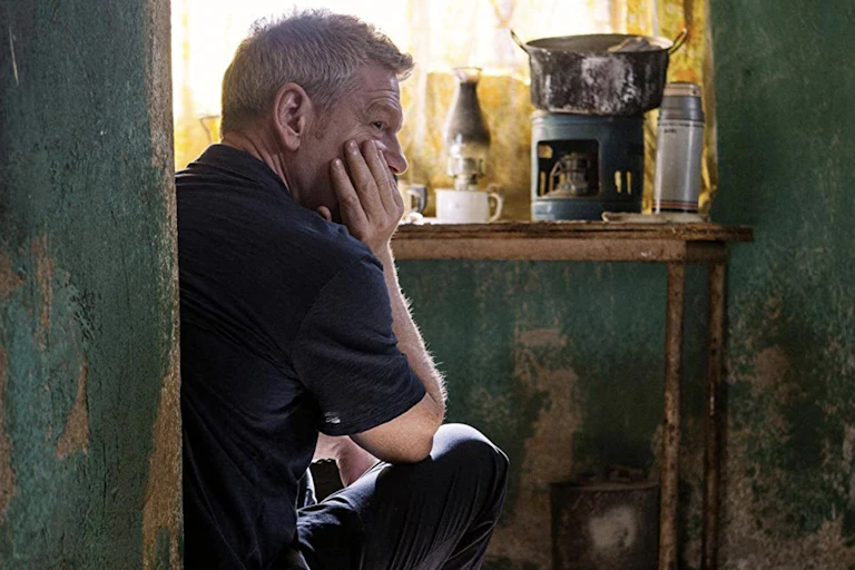 Man looks tired and contemplative in impoverished home