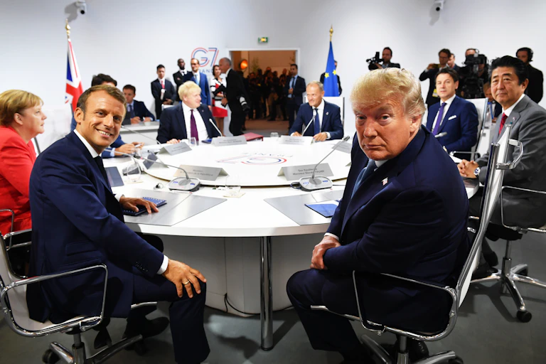 Emmanuel Macron and Donald Trump around a table with Angela Merkel Boris Johnson Donald Tusk Giuseppe Conte and Shinzo Abe.