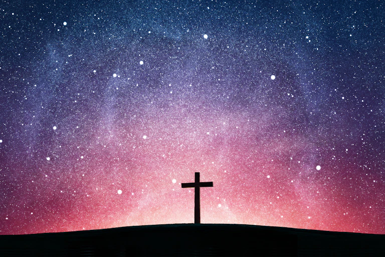 Picture of a wooden cross against a starry sky.