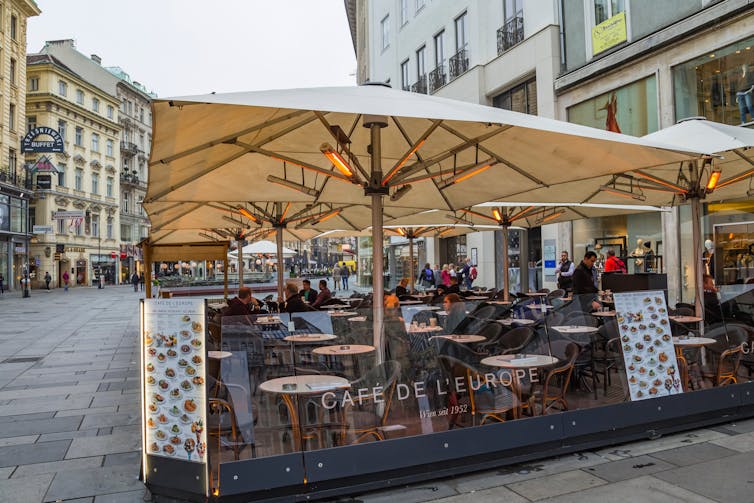 A cafe with infrared heaters under an umbrella.