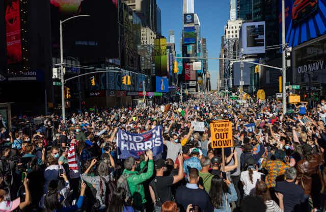 Crowds holding pro-Biden and anti-Trump signs in Times Square