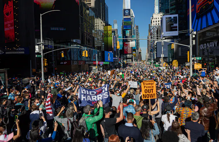 Crowds holding pro-Biden and anti-Trump signs in Times Square