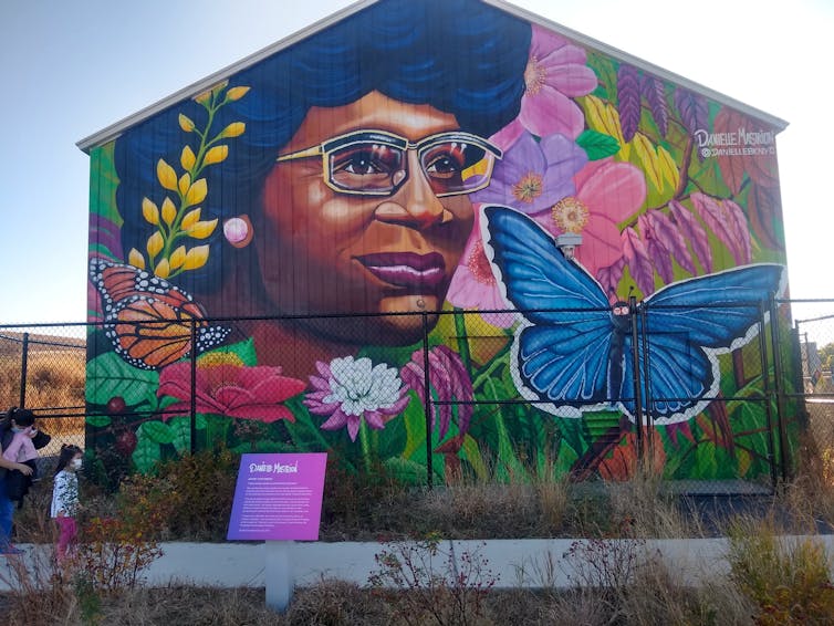 Colorful mural of Chisholm with butterflies and flowers