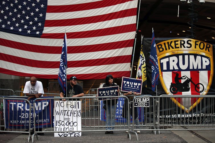 Trump supporters carry signs alleging an illegal election