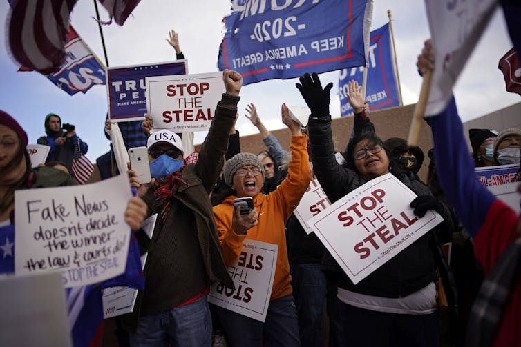 Trump supporters holding signs saying 'stop the steal' while protesting the election result