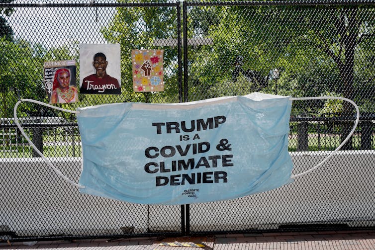 Sign on a fence in the US saying 'Trump: COVID and climate denier'.