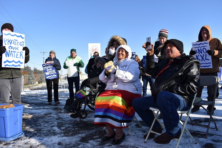 People hold signs against the Keystone XL pipeline.