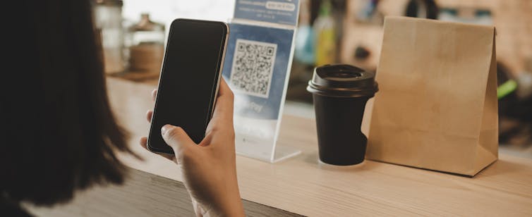 A woman uses a QR code at a restaurant