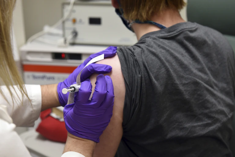 Someone receiving an injection from a health-care worker