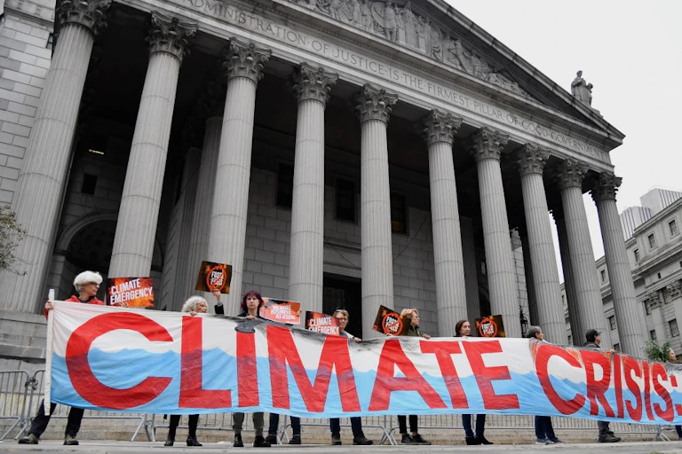 Des manifestants tenant une banderole où l'on peut lire «Climate crisis» à New York en 2019