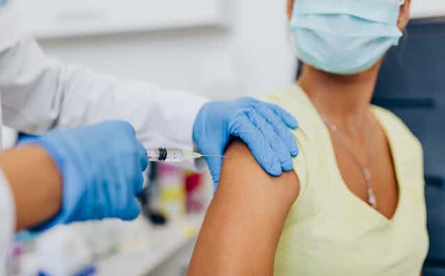 A woman receiving a vaccine in her arm