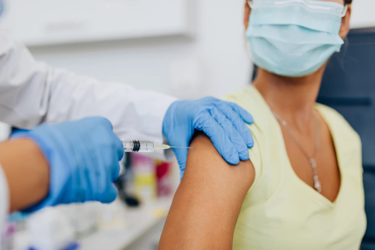 A woman receiving a vaccine in her arm