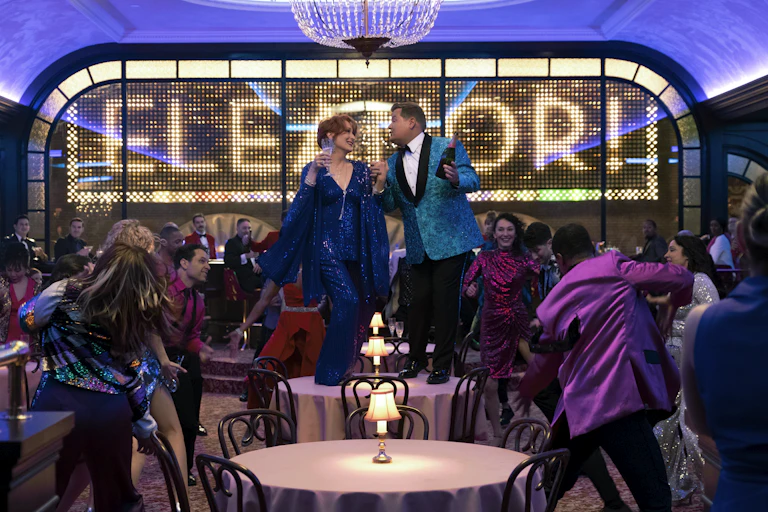 Meryl Streep and James Corden singing on a table.