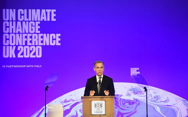 Governor of the Bank of England Mark Carney stands before a lectern at an event launching COP26.