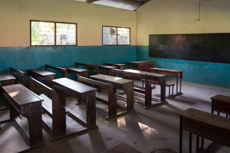 Aula con pupitres de madera vacía.
