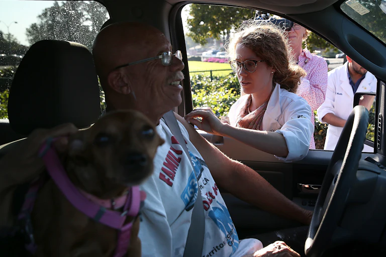 A man gets a flu shot at a drive-through clinic.