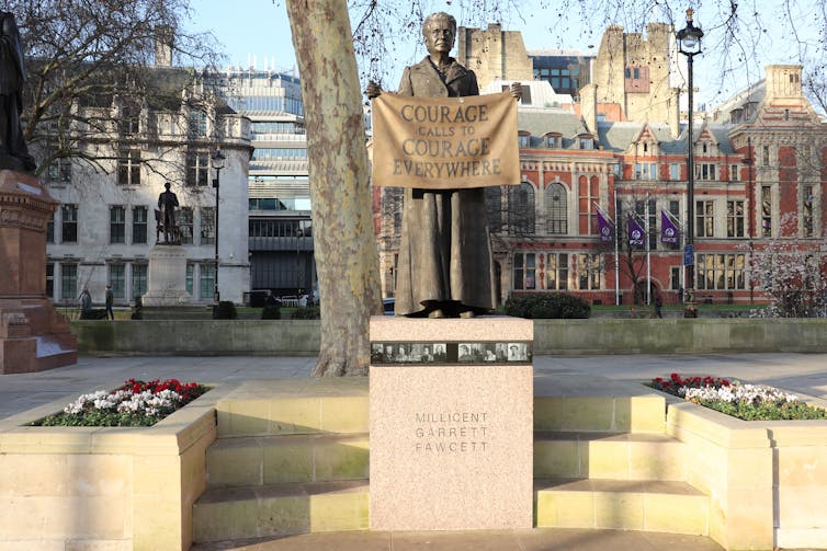 Statue of Millicent Fawcett holding a banner saying 'Courage calls to courage everywhere'