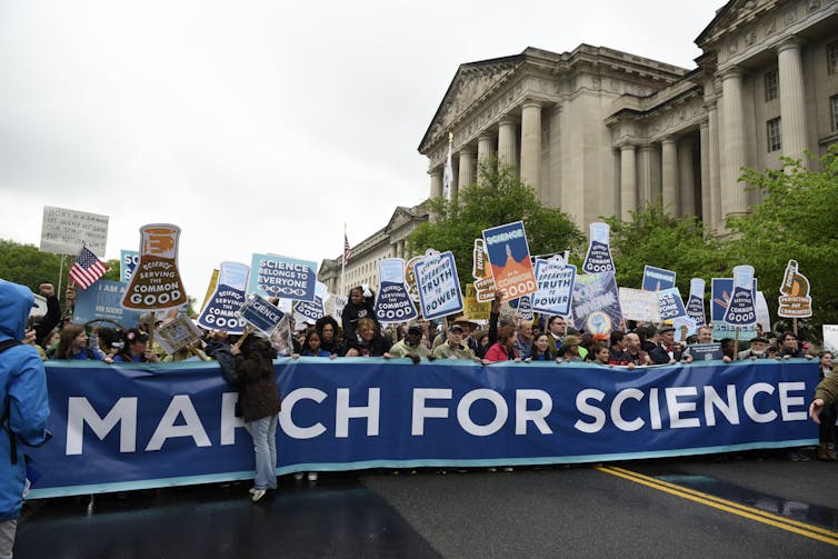 people with signs at a March for Science in DC