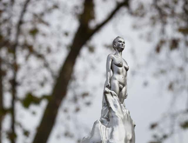 staute of a silver lady emerging from a silver flurry.