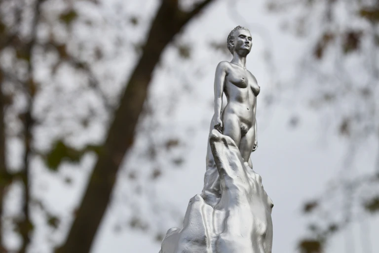 staute of a silver lady emerging from a silver flurry.
