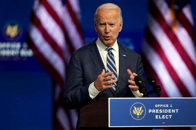 Biden speaks in front of a podium that reads Office of the President-elect
