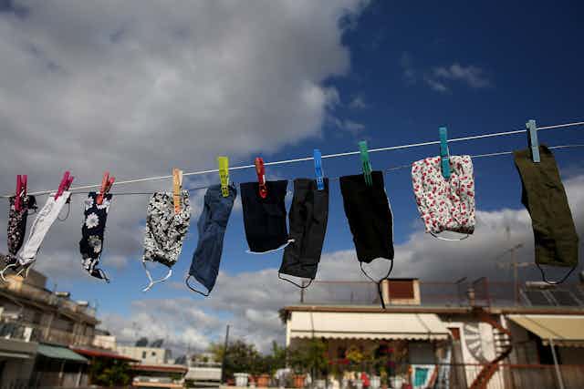 Face masks hanging up to dry on a washing line.