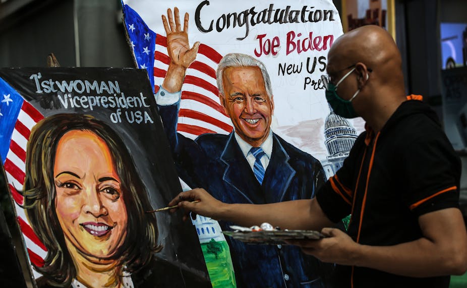 An artist painting a picture of Kamala Harris and Joe Biden