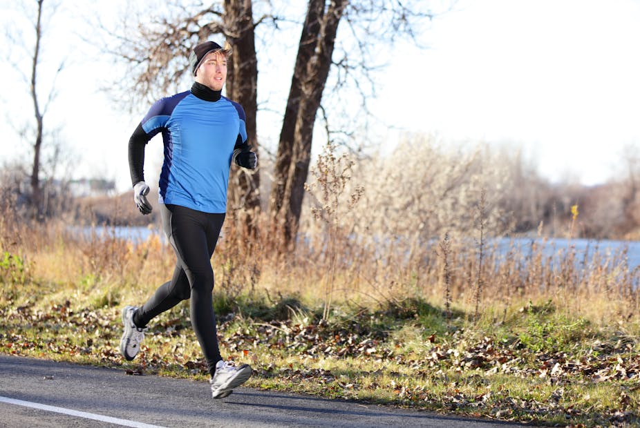 Young man running outdoors on a cold, sunny Autumn or winter day.