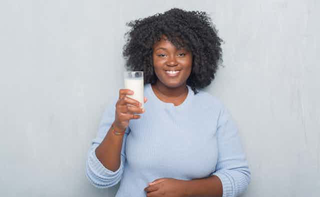 Woman holding up a glass of milk