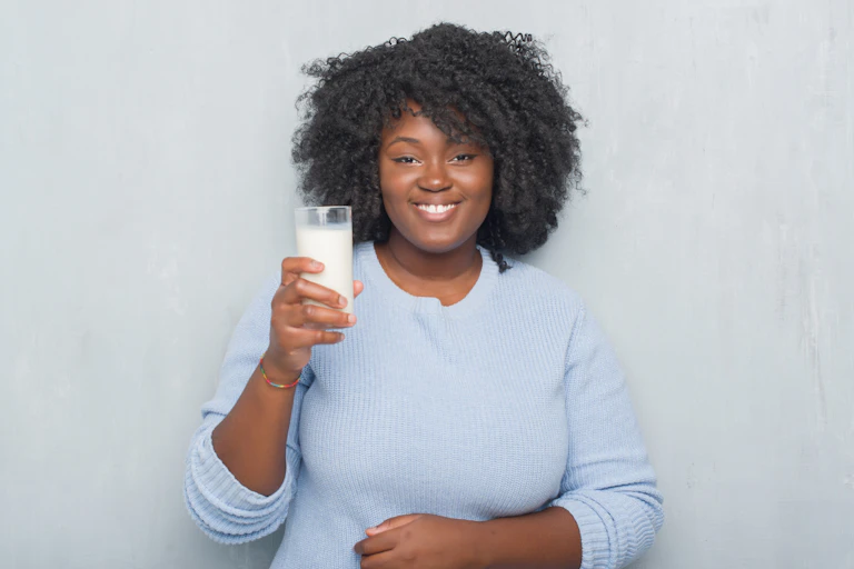Woman holding up a glass of milk