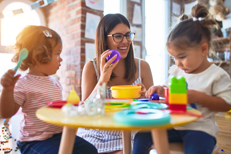 Teacher at preschool playing with children