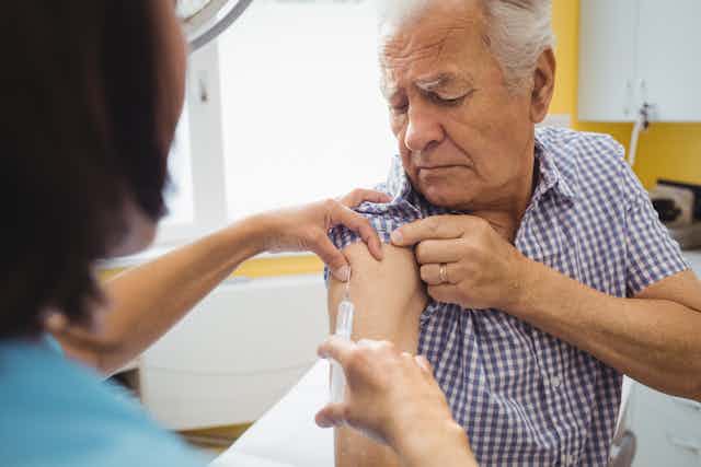An older gentleman receives a vaccine.