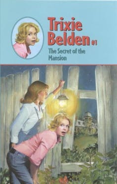 Trixie Belden book cover. Two girls peek through curtain.