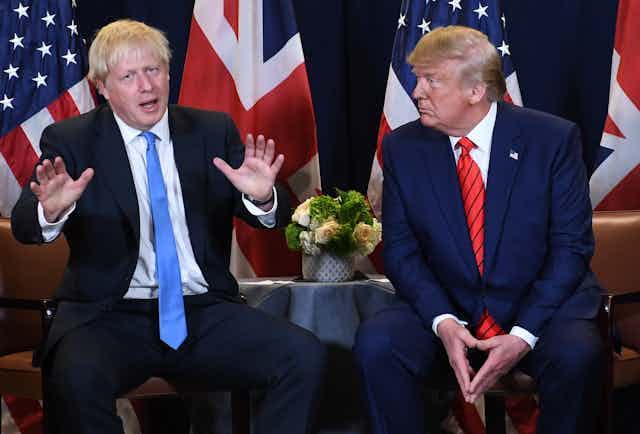 Boris Johnson and Donald Trump in front of their national flags. 