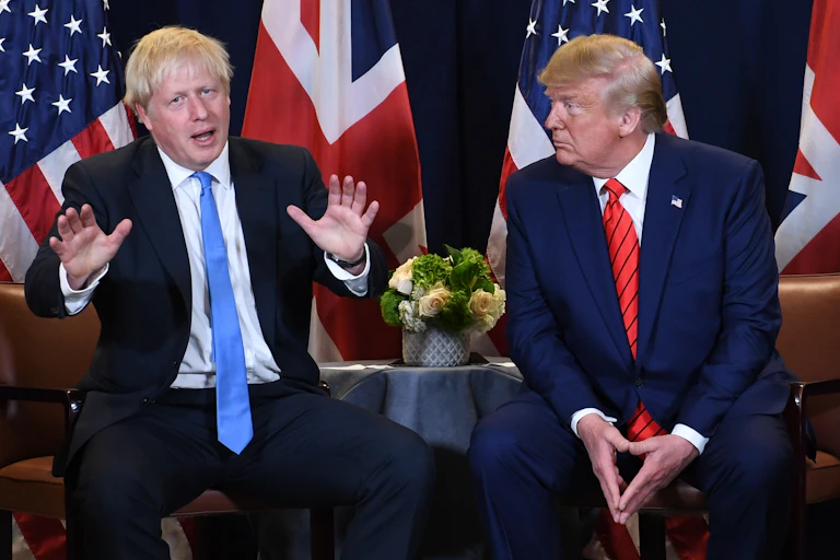 Boris Johnson and Donald Trump in front of their national flags.