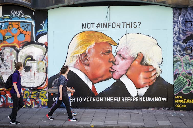 Graffiti depicting Donald Trump and Boris Johnson kissing, in the style of the famous mural 'My God, Help Me to Survive This Fatal Attraction', painted on the Berlin Wall.